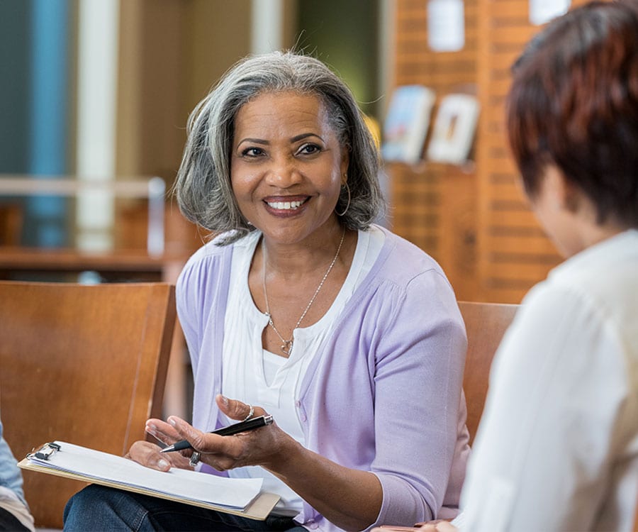 Counseling - Seasons Hospice MO | End of Life Care | Springfield, MO A grief counselor shares a spark of joy with her client as they sit near one another.