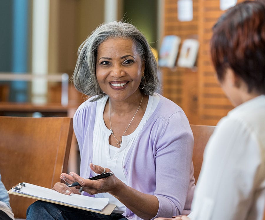 A grief counselor shares a spark of joy with her client as they sit near one another.