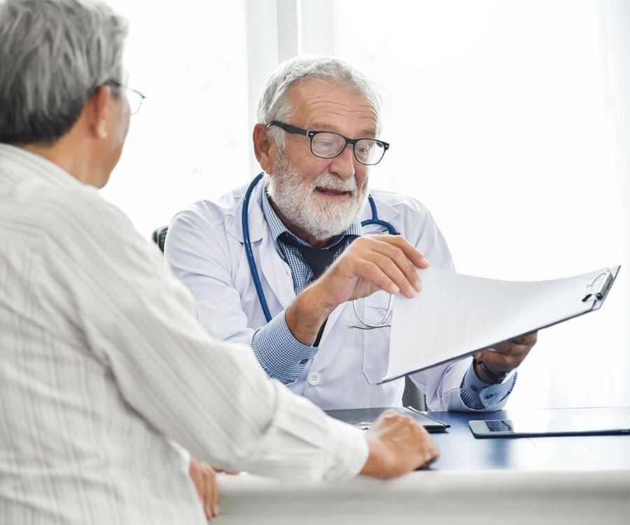 A doctor explains a plan of care to his patient in a pleasant exchange.